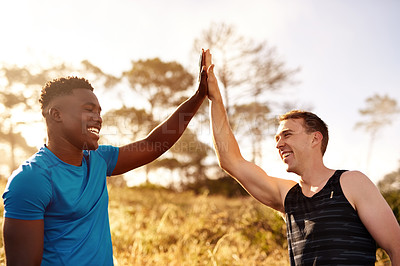 Buy stock photo Cropped shot of two sporty young men high fiving each other outside