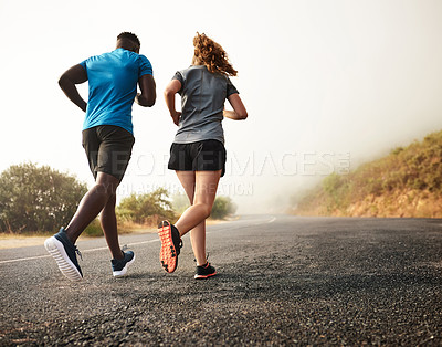 Buy stock photo Rear view shot of two sporty young people out for a run together