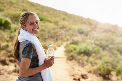 Buy stock photo Portrait of a sporty young woman taking a break while out for a run