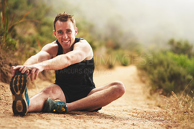 Buy stock photo Portrait of a sporty young man stretching before a run outside