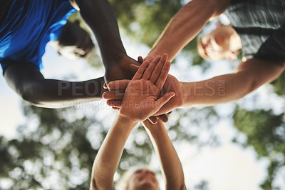 Buy stock photo Low angle shot of a group of sporty young people holding their hands together in unity