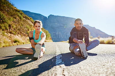 Buy stock photo Portrait of a sporty young couple stretching before a run outside