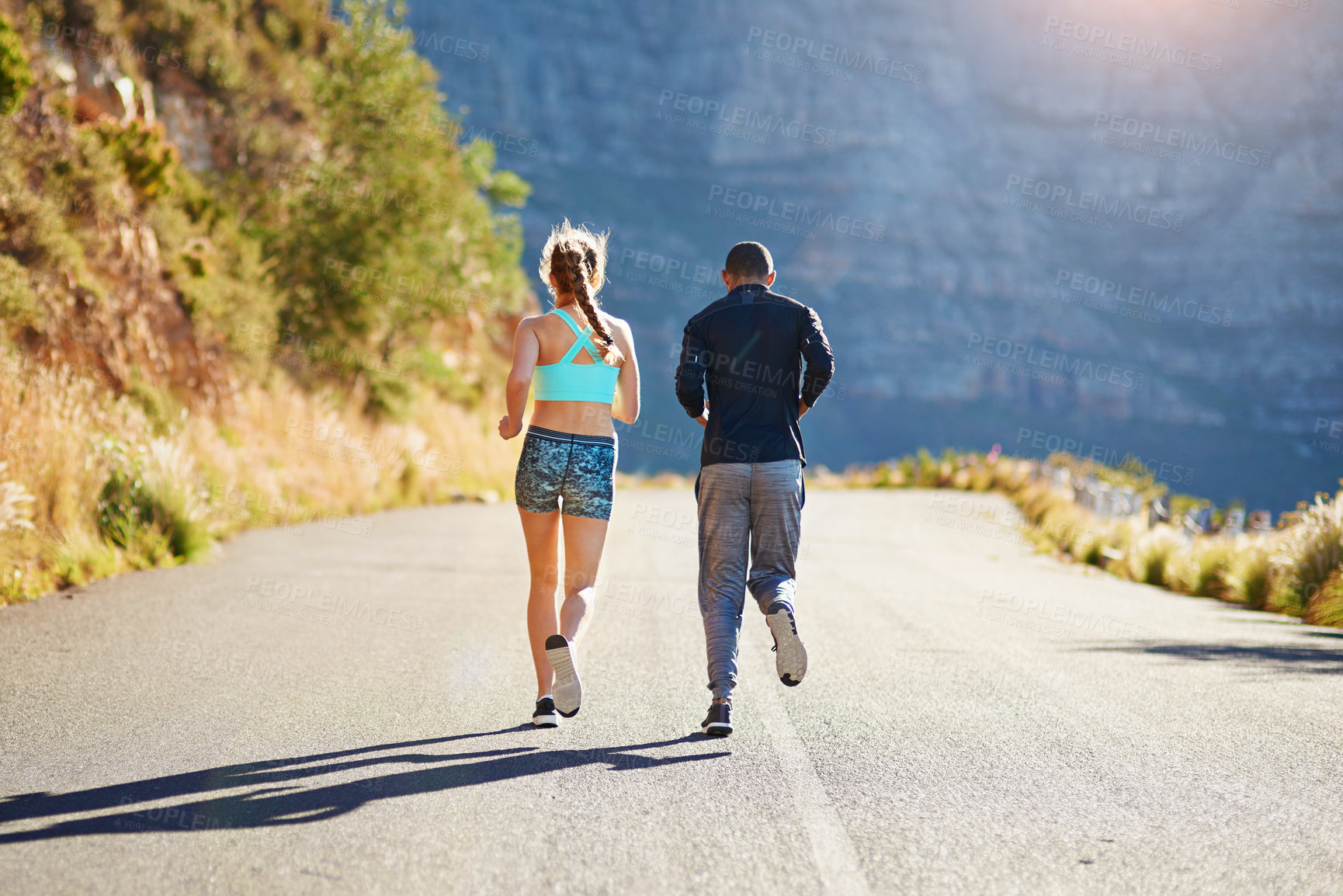 Buy stock photo Running, man and woman on road in mountain for fitness, support or marathon training together from back. Morning race, runner and personal trainer on path in nature for outdoor workout challenge 