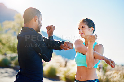 Buy stock photo Cropped shot of a sporty young couple stretching before a run outside