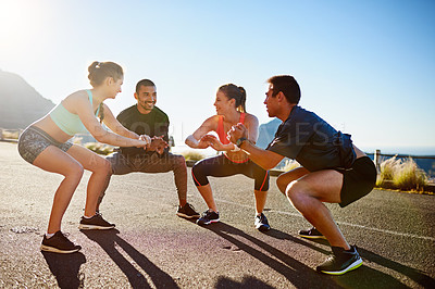 Buy stock photo Shot of a fitness group stretching before a run outside