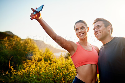 Buy stock photo Cropped shot of a sporty young couple taking a selfie while out for a run together