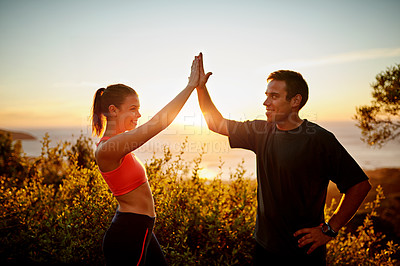 Buy stock photo Cropped shot of a sporty young couple high fiving each other outside