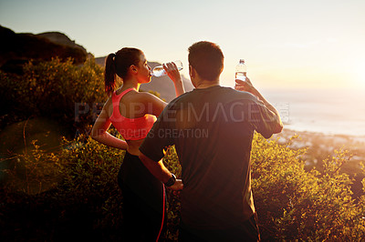 Buy stock photo Cropped shot of a sporty young couple taking a break while out for a run together