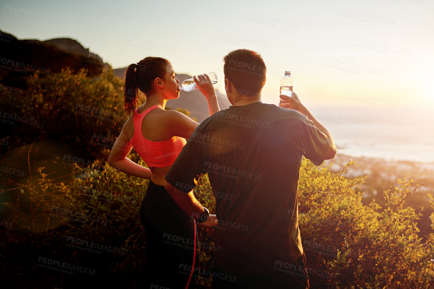 Buy stock photo Cropped shot of a sporty young couple taking a break while out for a run together