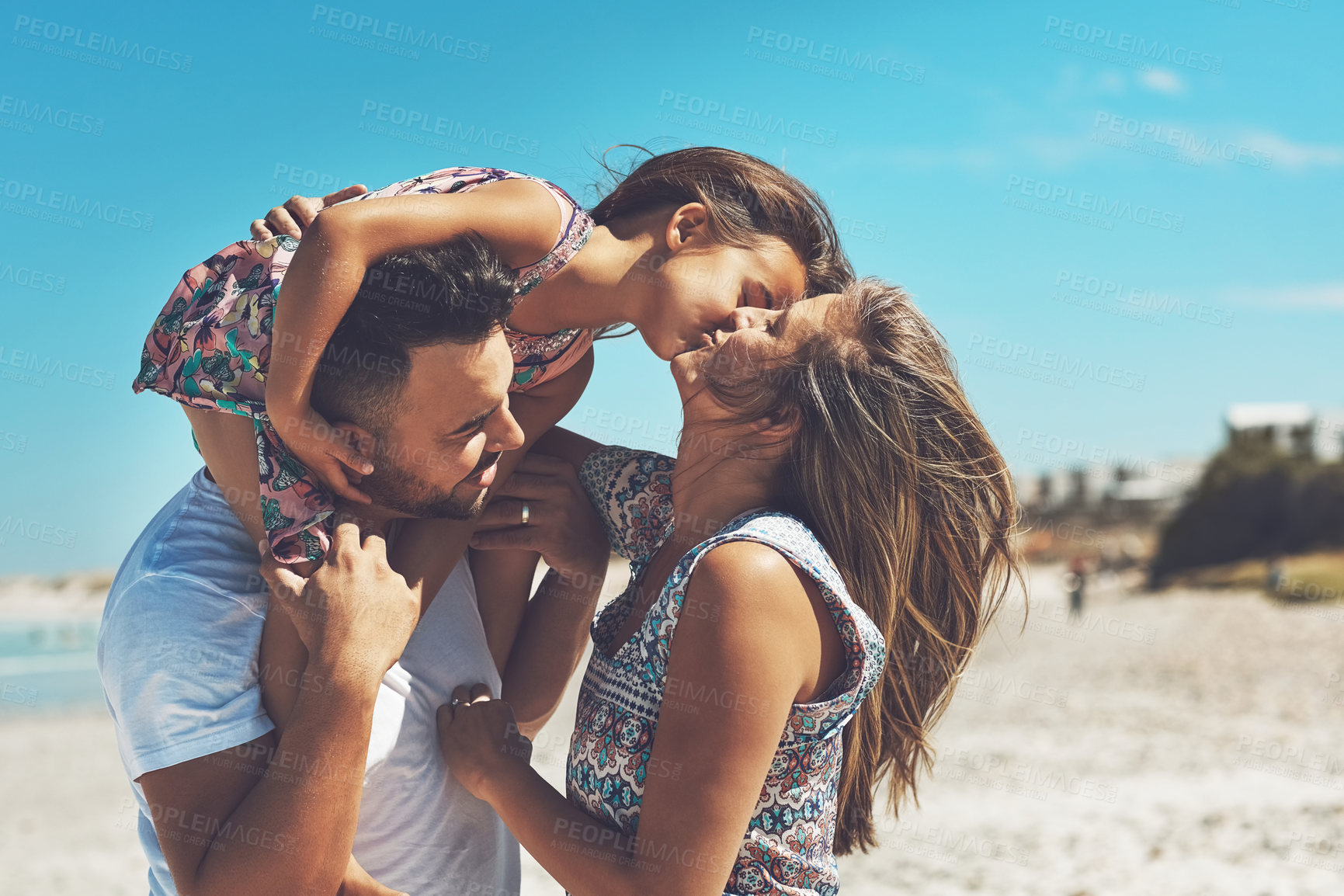 Buy stock photo Cropped shot of a happy young family enjoying their day at the beach