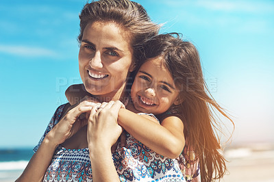 Buy stock photo Cropped portrait of a young mother and her daughter enjoying a day at the beach