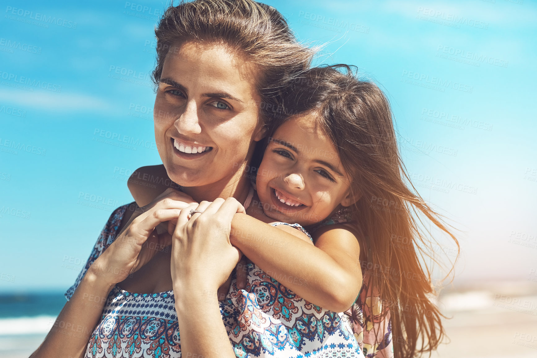 Buy stock photo Happy mother, portrait and hug with daughter at beach for summer holiday, weekend or bonding together in nature. Mom with child, kid or little girl for piggyback or outdoor vacation by ocean coast