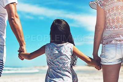 Buy stock photo Rearview shot of a happy young family enjoying their day at the beach