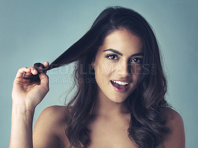 Buy stock photo Studio shot of a beautiful young woman playing with her hair