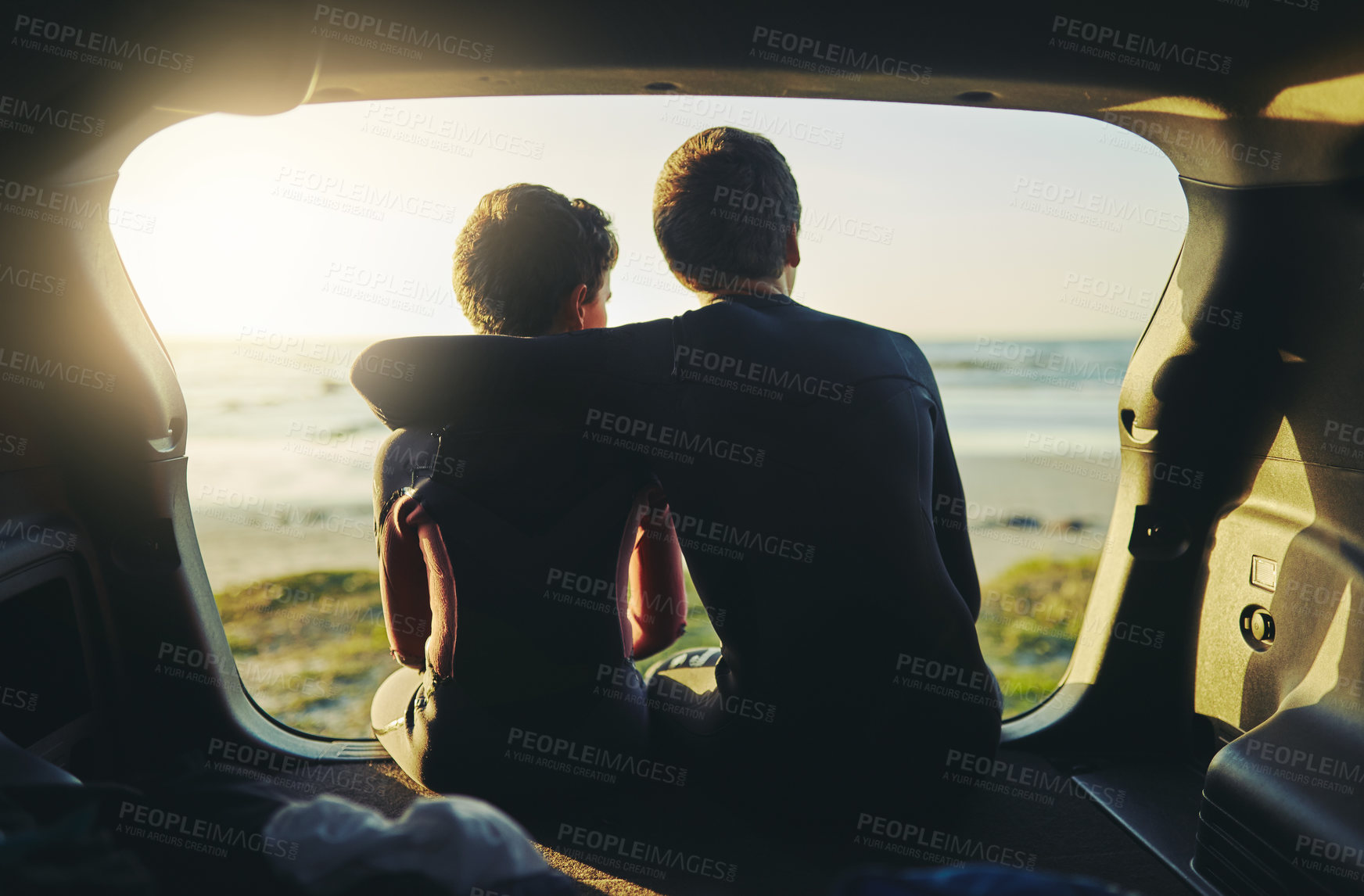 Buy stock photo Rearview shot of two unidentifiable brothers sitting in the back of a car at the beach