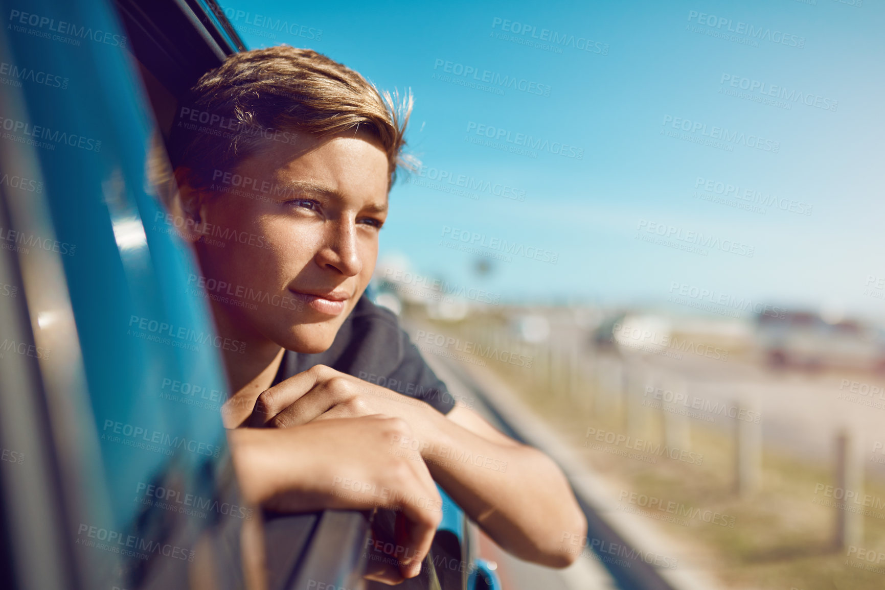 Buy stock photo Shot of a happy young boy leaning out of the car window on a trip to the beach