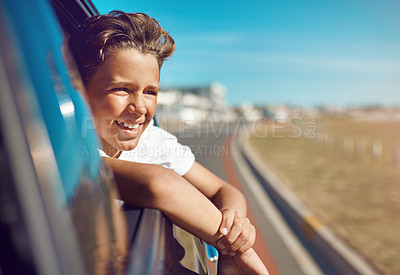 Buy stock photo Shot of a happy young boy leaning out of the car window on a trip to the beach