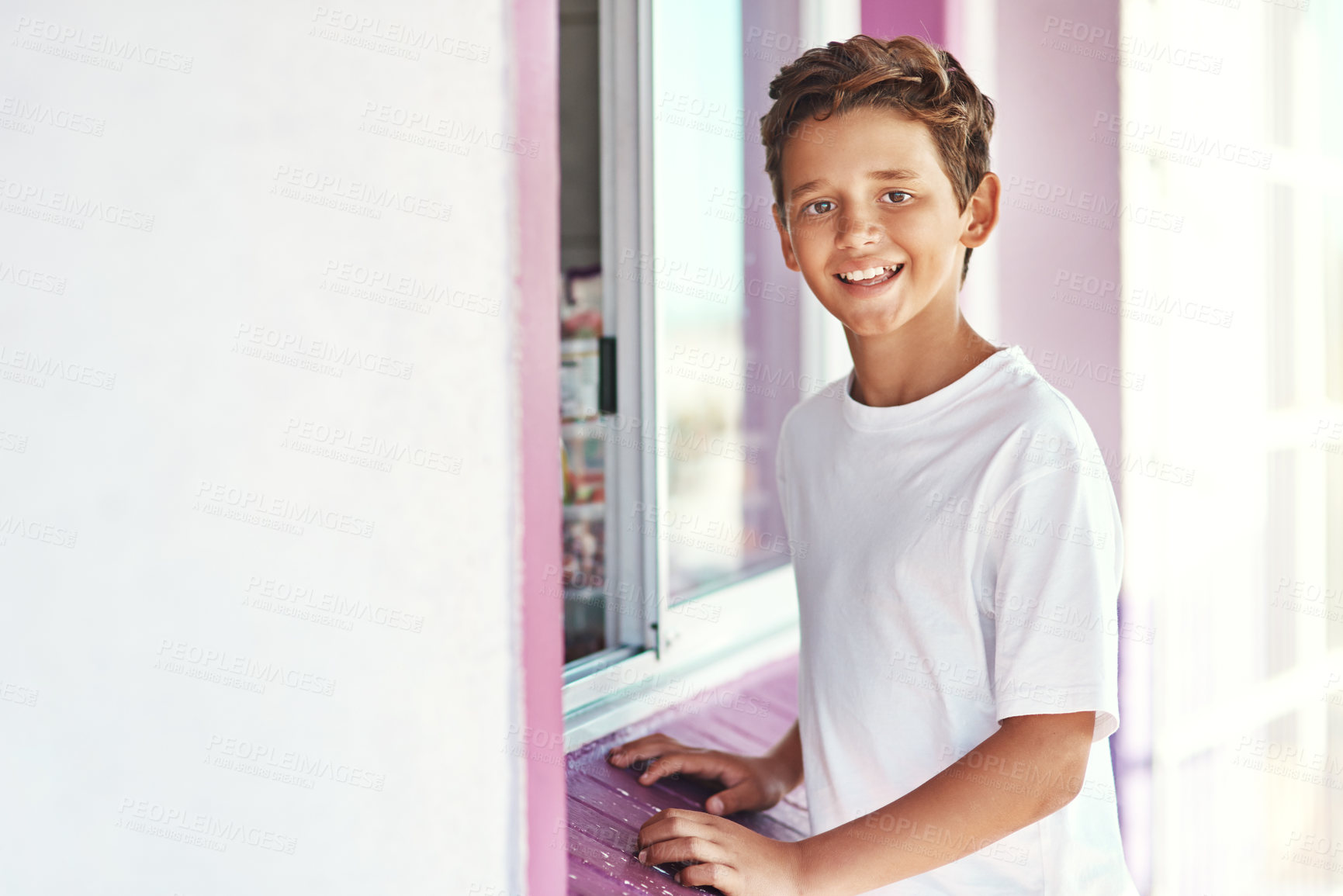 Buy stock photo Portrait of a cheerful little boy standing outside an ice-cream shop by the beach