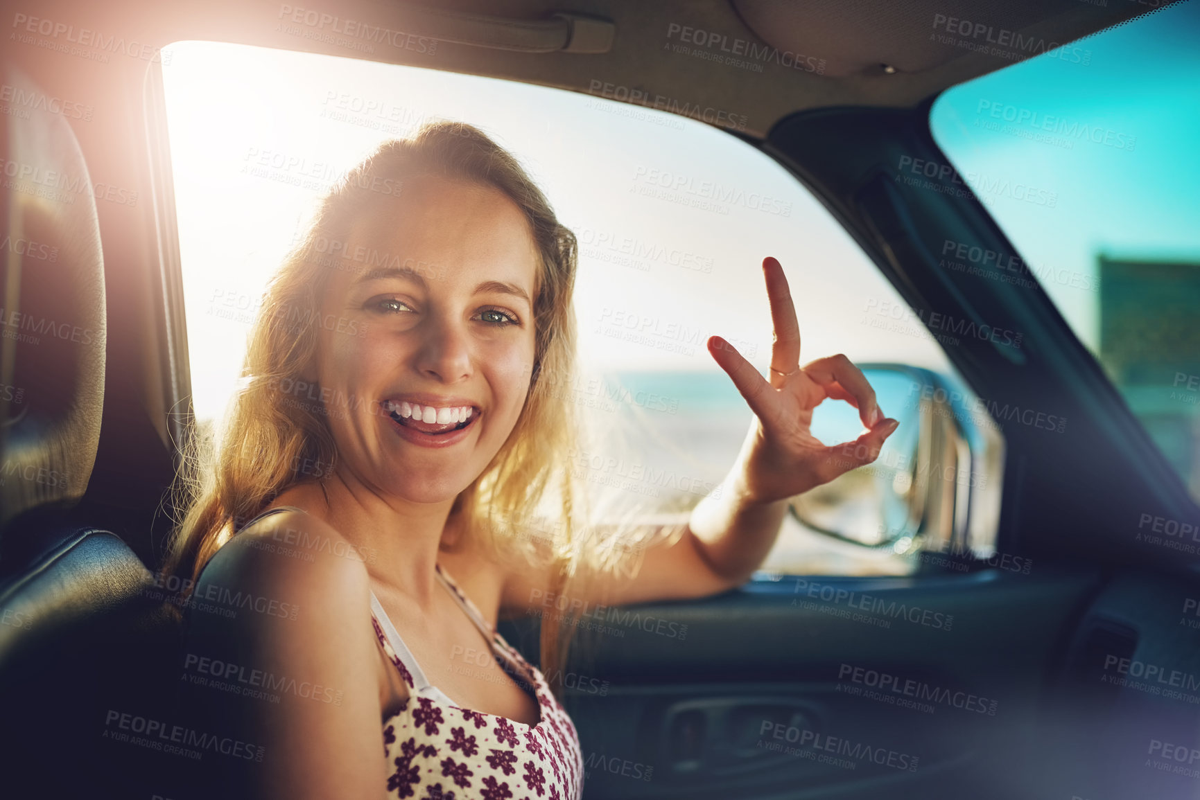 Buy stock photo Cropped portrait of an attractive young woman showing a piece sign while on a roadtrip