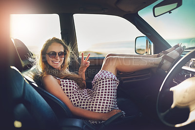 Buy stock photo Portrait of an attractive young woman showing a piece sign while on a roadtrip