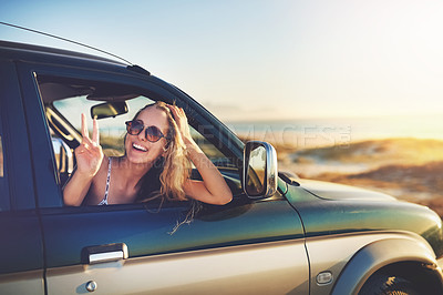 Buy stock photo Cropped portrait of an attractive young woman showing a piece sign while on a roadtrip
