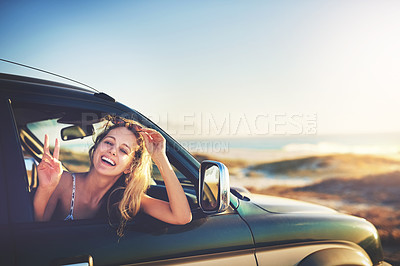 Buy stock photo Cropped portrait of an attractive young woman showing a piece sign while on a roadtrip