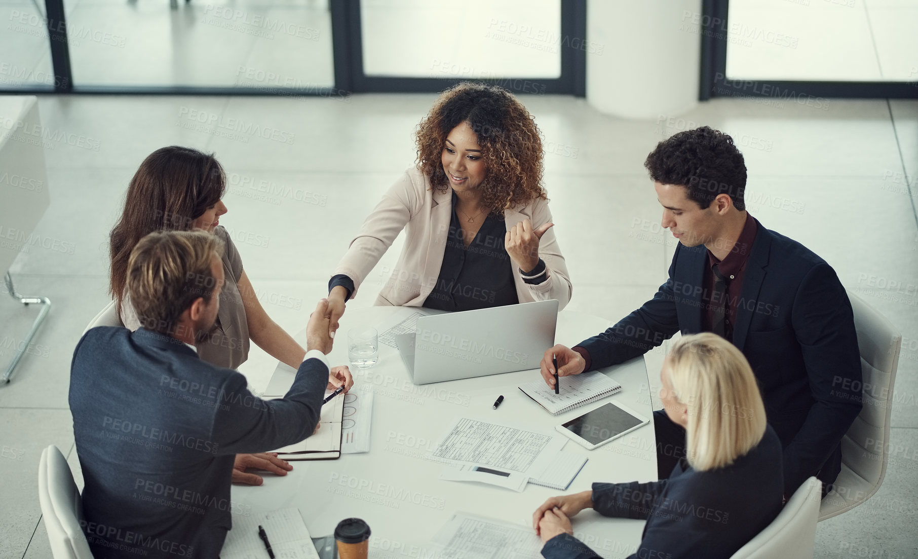 Buy stock photo Shot of a businessman and businesswoman shaking hands during a meeting in a modern office