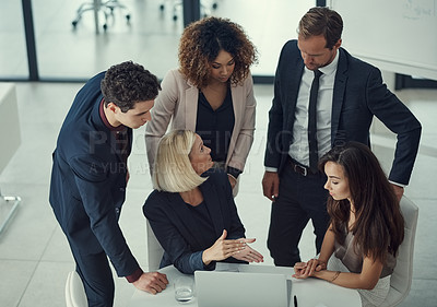 Buy stock photo Shot of a group of colleagues using laptop together during a meeting in a modern office