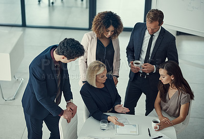 Buy stock photo Shot of a group of colleagues collaborating on a project in a modern office