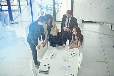 Buy stock photo Shot of a group of colleagues using digital tablet together during a meeting in a modern office