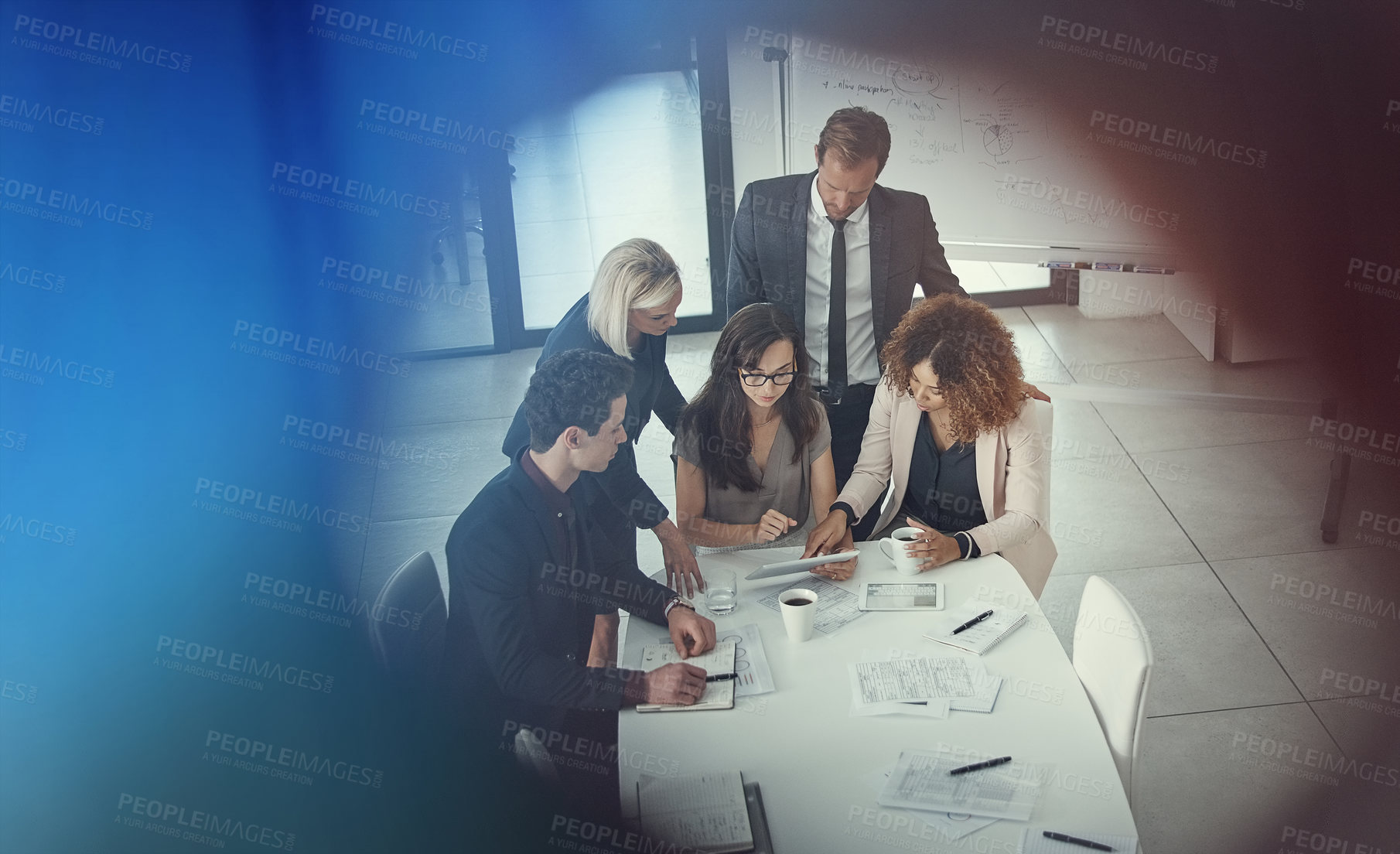 Buy stock photo Shot of a group of colleagues using digital tablet together during a meeting in a modern office