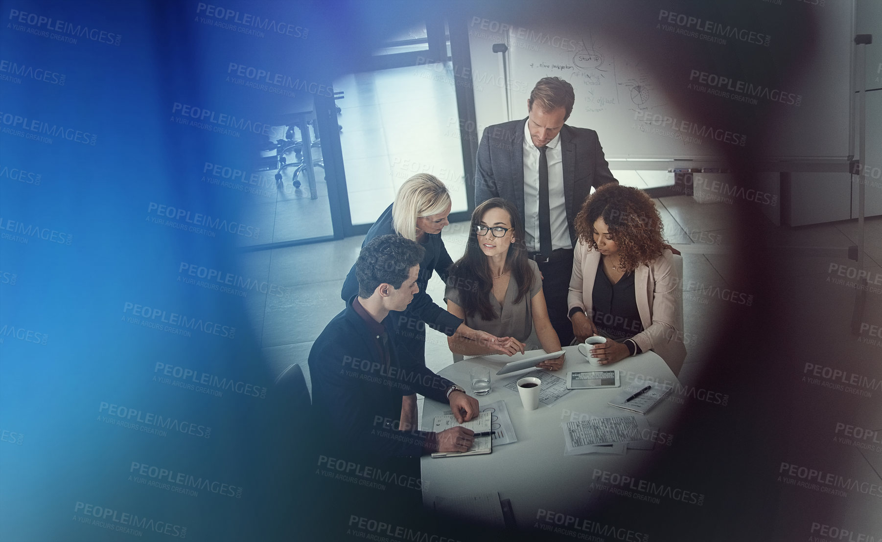 Buy stock photo Shot of a group of colleagues using digital tablet together during a meeting in a modern office