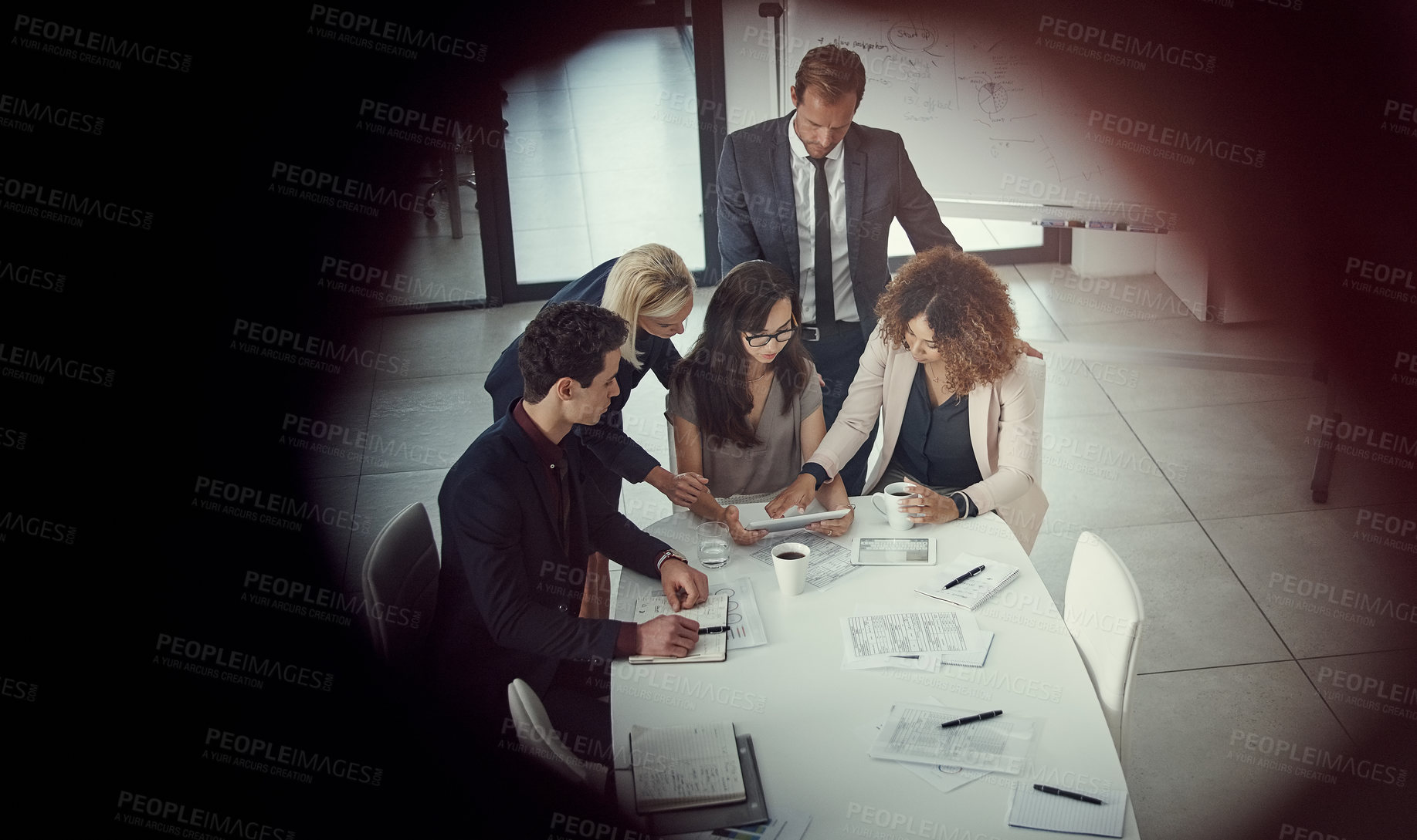 Buy stock photo Shot of a group of colleagues using digital tablet together during a meeting in a modern office