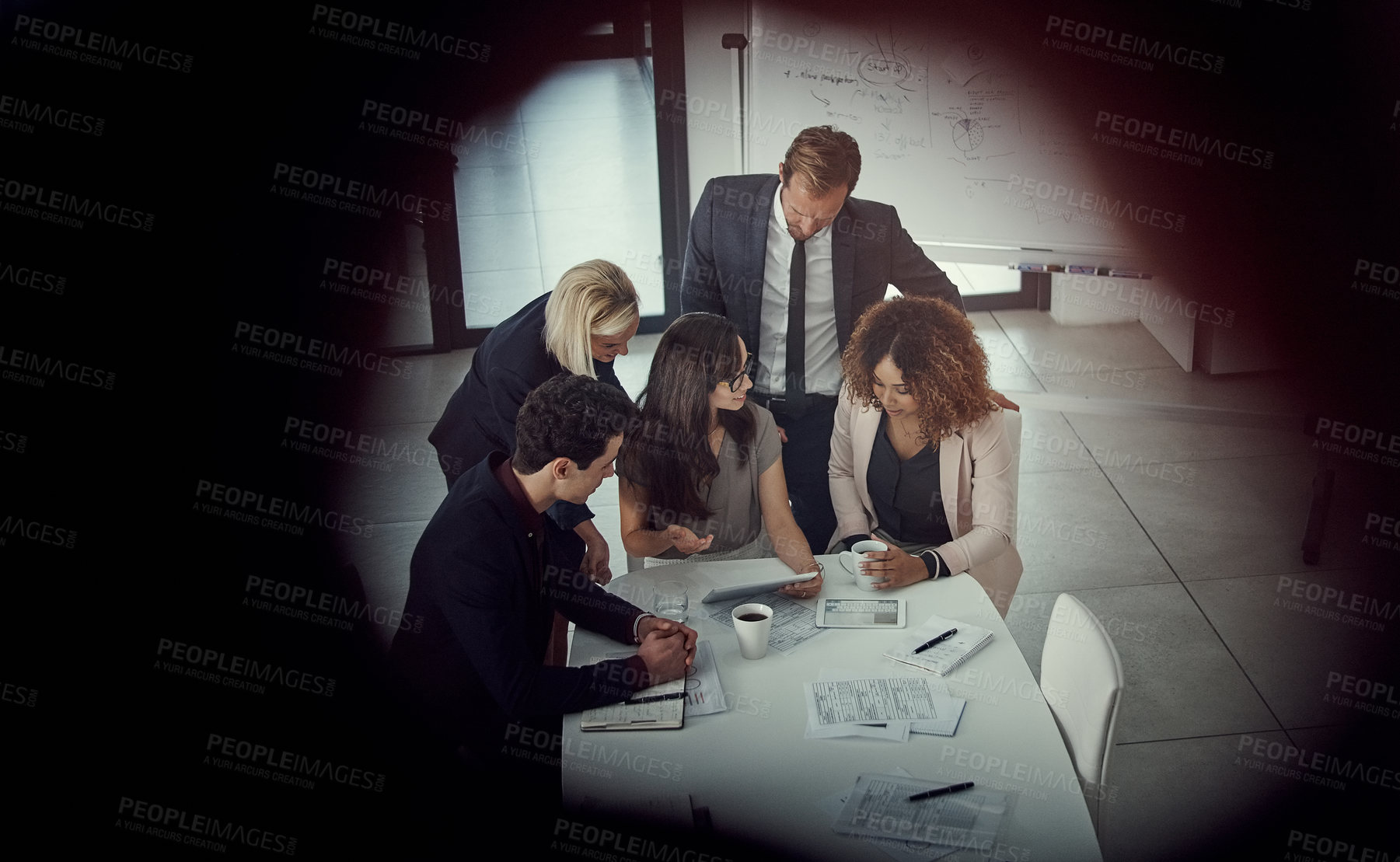 Buy stock photo Shot of a group of colleagues using digital tablet together during a meeting in a modern office