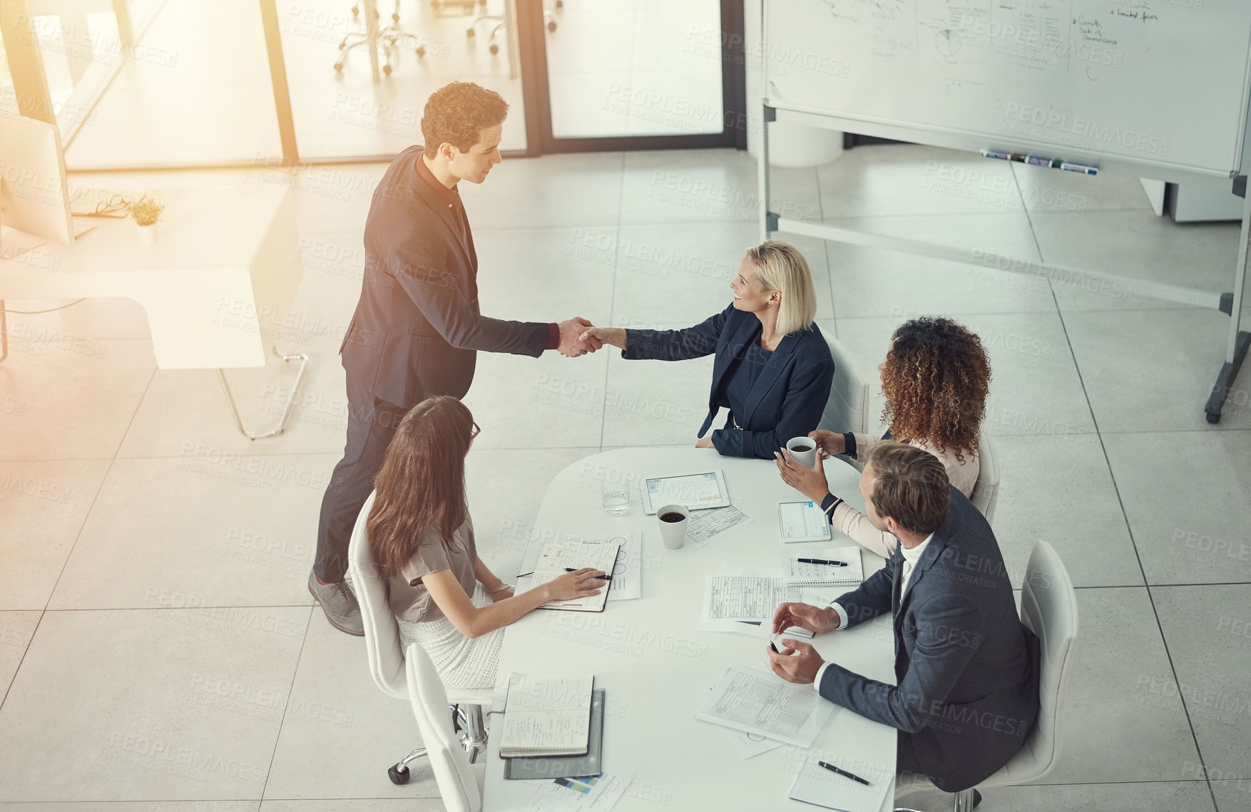 Buy stock photo Shot of a businessman and businesswoman shaking hands during a meeting in a modern office