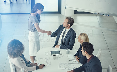 Buy stock photo Shot of a businessman and businesswoman shaking hands during a meeting in a modern office