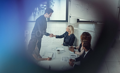 Buy stock photo Shot of a businessman and businesswoman shaking hands during a meeting in a modern office