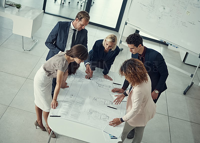 Buy stock photo Shot of a team of corporate architects collaborating on a plan in a modern office