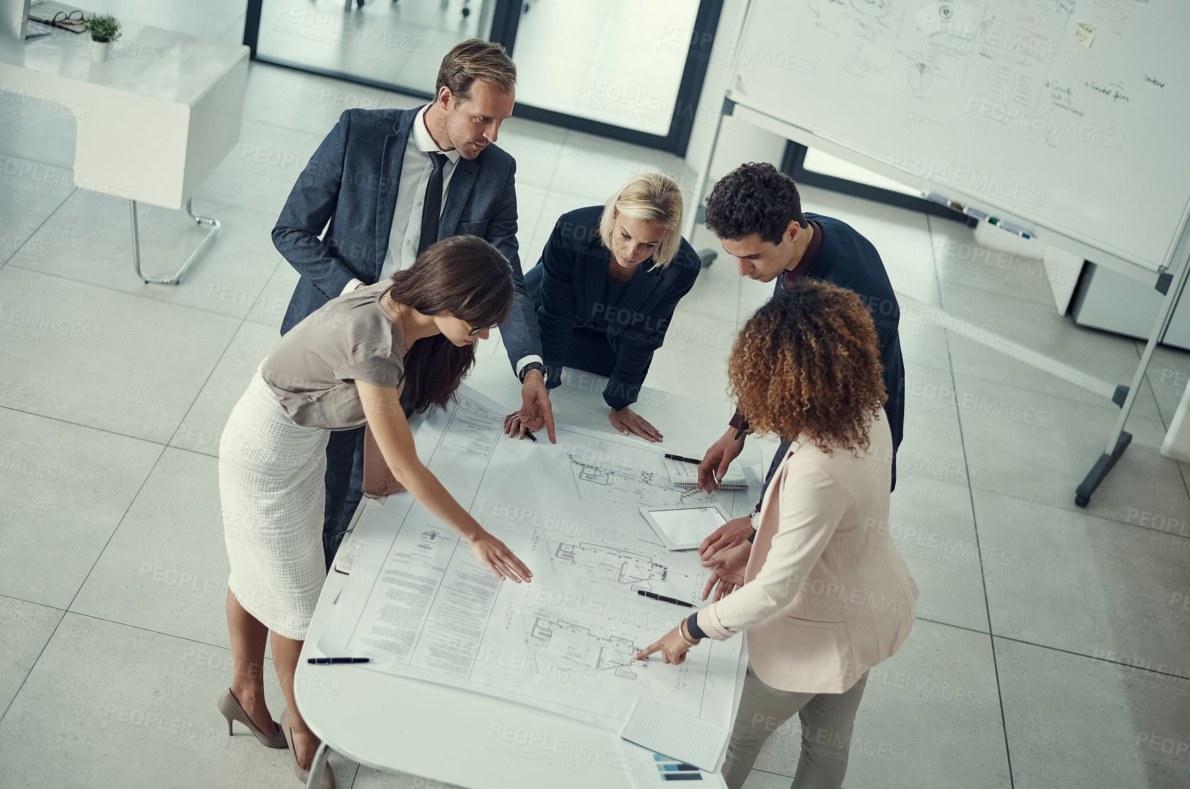 Buy stock photo Shot of a team of corporate architects collaborating on a plan in a modern office