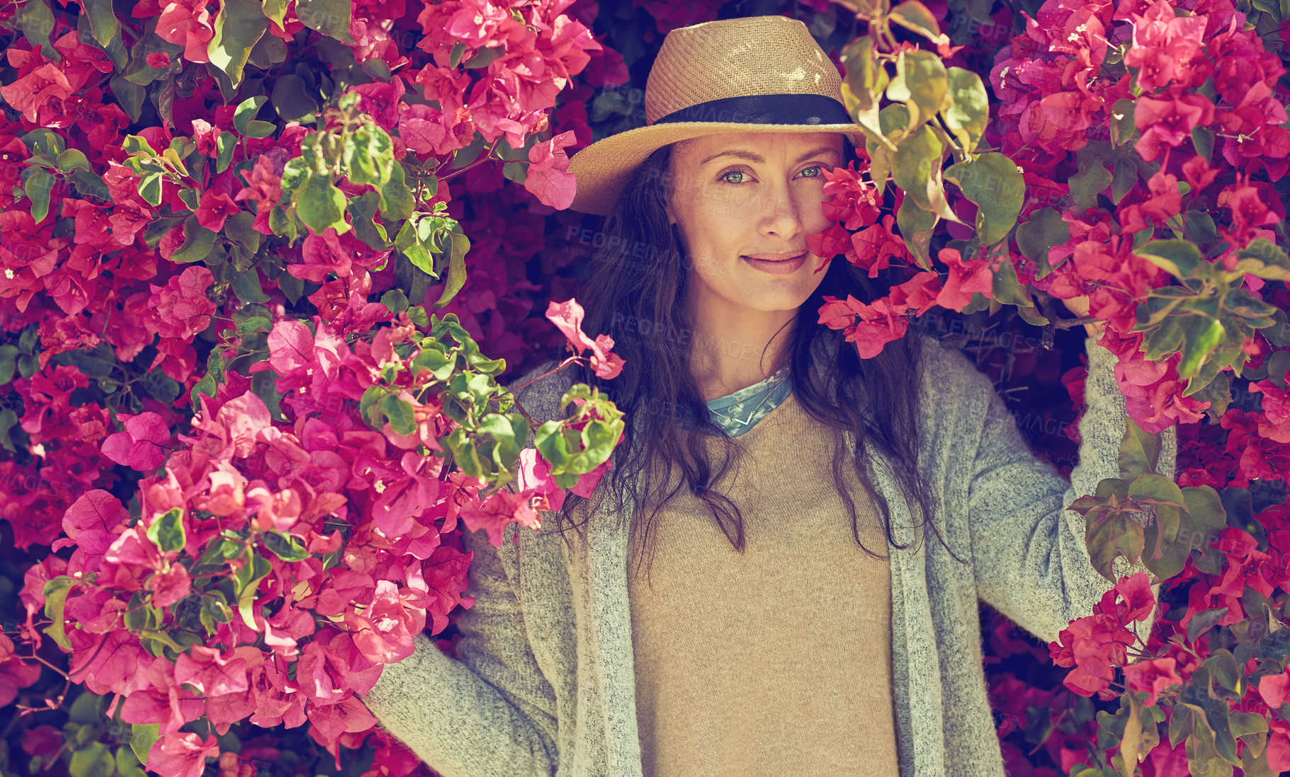 Buy stock photo Shot of an attractive young woman standing under a tree with beautiful pink flowers