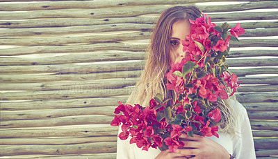 Buy stock photo Shot of an attractive young woman holding a bunch of fresh flowers