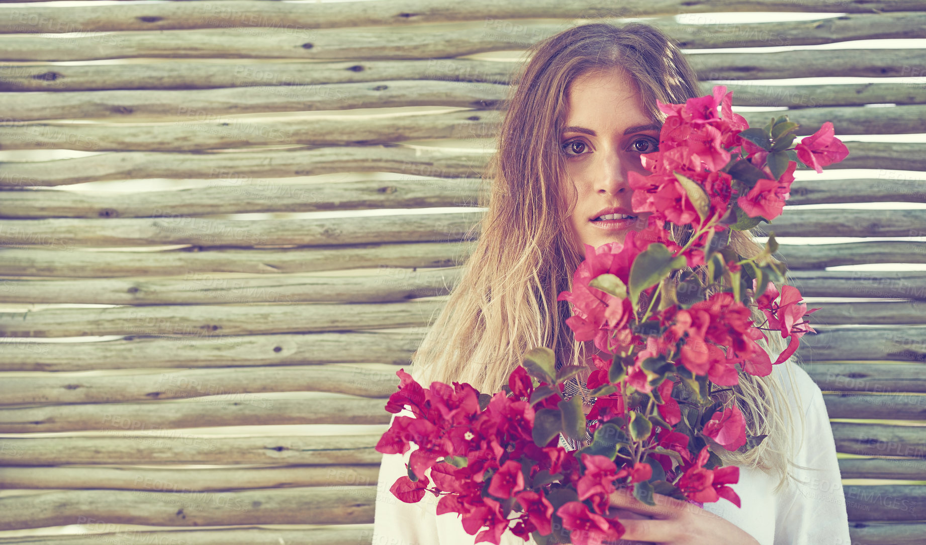 Buy stock photo Shot of an attractive young woman holding a bunch of fresh flowers