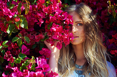 Buy stock photo Shot of an attractive young woman standing under a tree with beautiful pink flowers