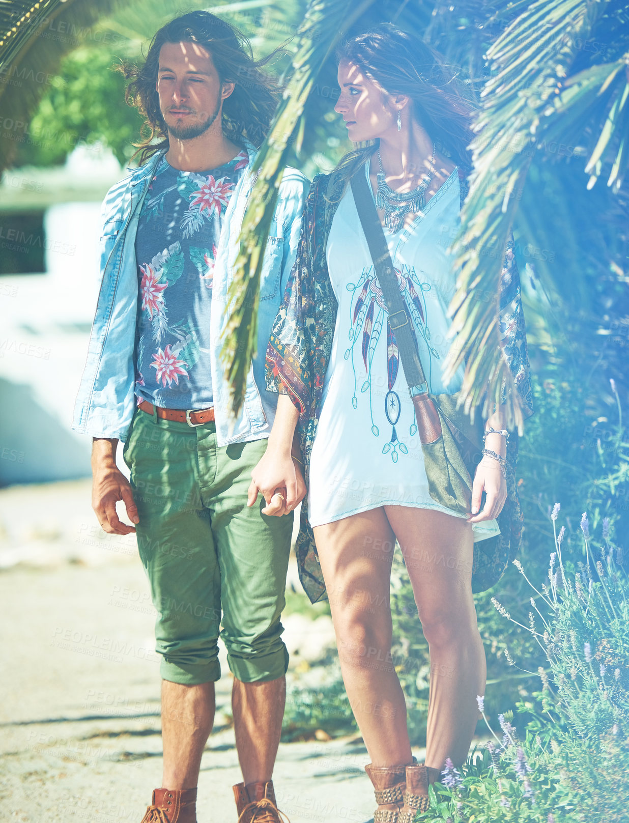 Buy stock photo Couple, fashion or palm tree leaves with love for floral aesthetic, sustainable clothes or nature. Holding hands, people and organic outfit for summer season, bohemian style and tropical conservation