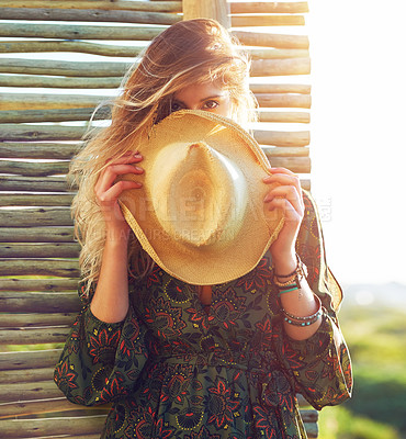 Buy stock photo Cropped shot of a young woman holding a hat over her face