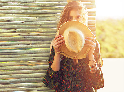 Buy stock photo Cropped shot of a young woman holding a hat over her face