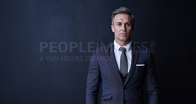 Buy stock photo Studio portrait of a confident and mature businessman standing against a dark background