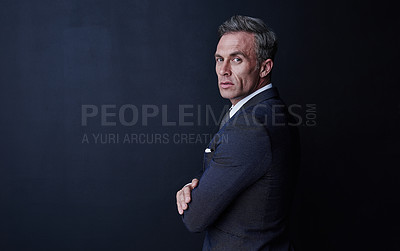 Buy stock photo Studio portrait of a confident and mature businessman standing against a dark background