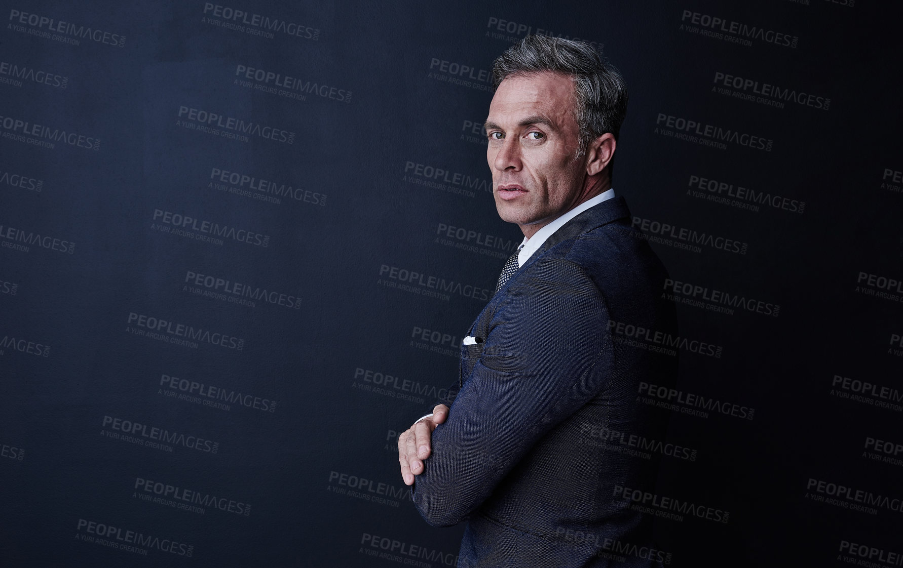 Buy stock photo Studio portrait of a confident and mature businessman standing against a dark background