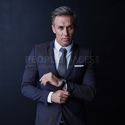 Buy stock photo Studio portrait of a stylish and mature businessman standing against a dark background